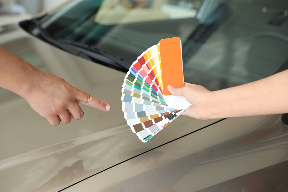 Mann wählt die Farbe des Lacks für sein Auto